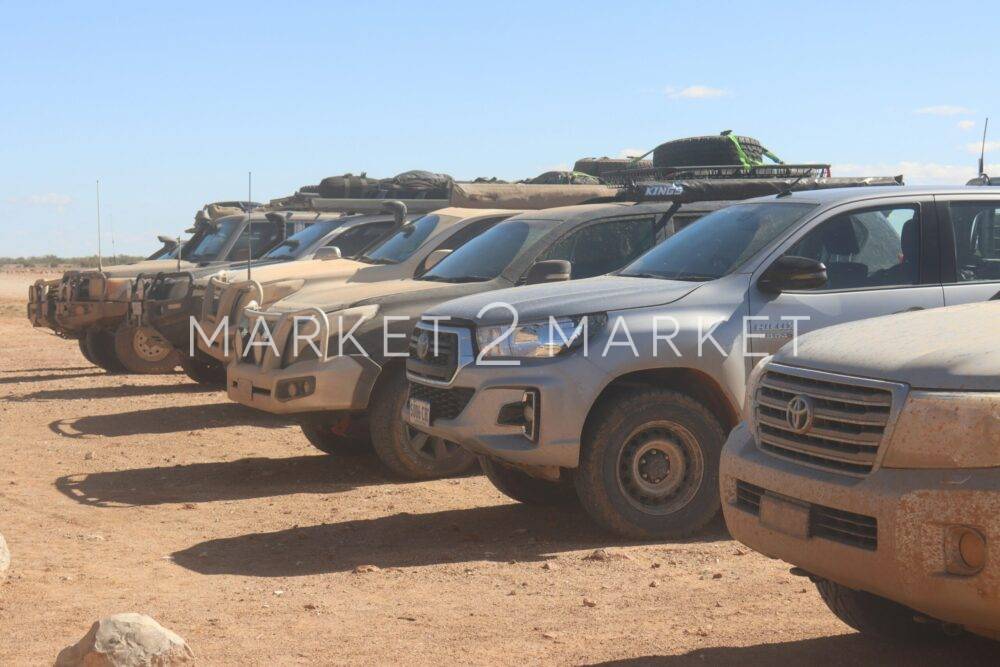 a bunch of trucks that are parked in the dirt