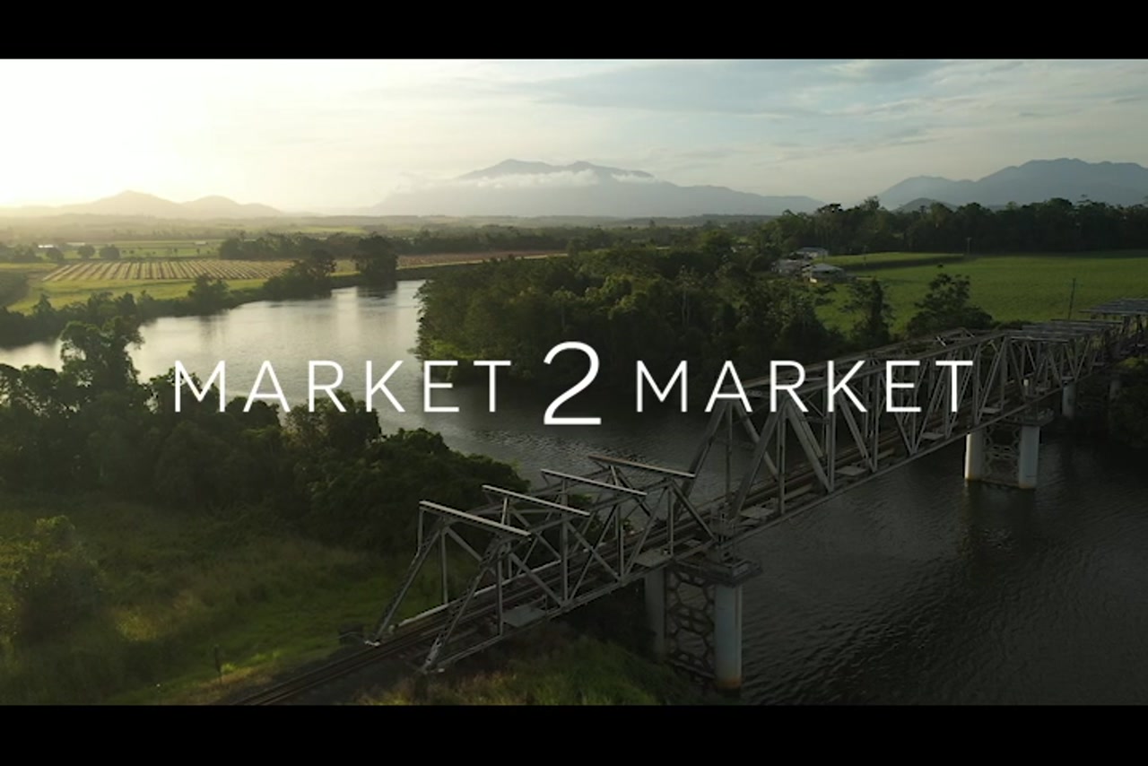 Aerial footage of train bridge over river and agricultural fields in Far North Queensland