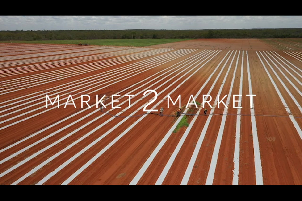 Aerial footage of dry, red earth, farmland with workers, North Queensland