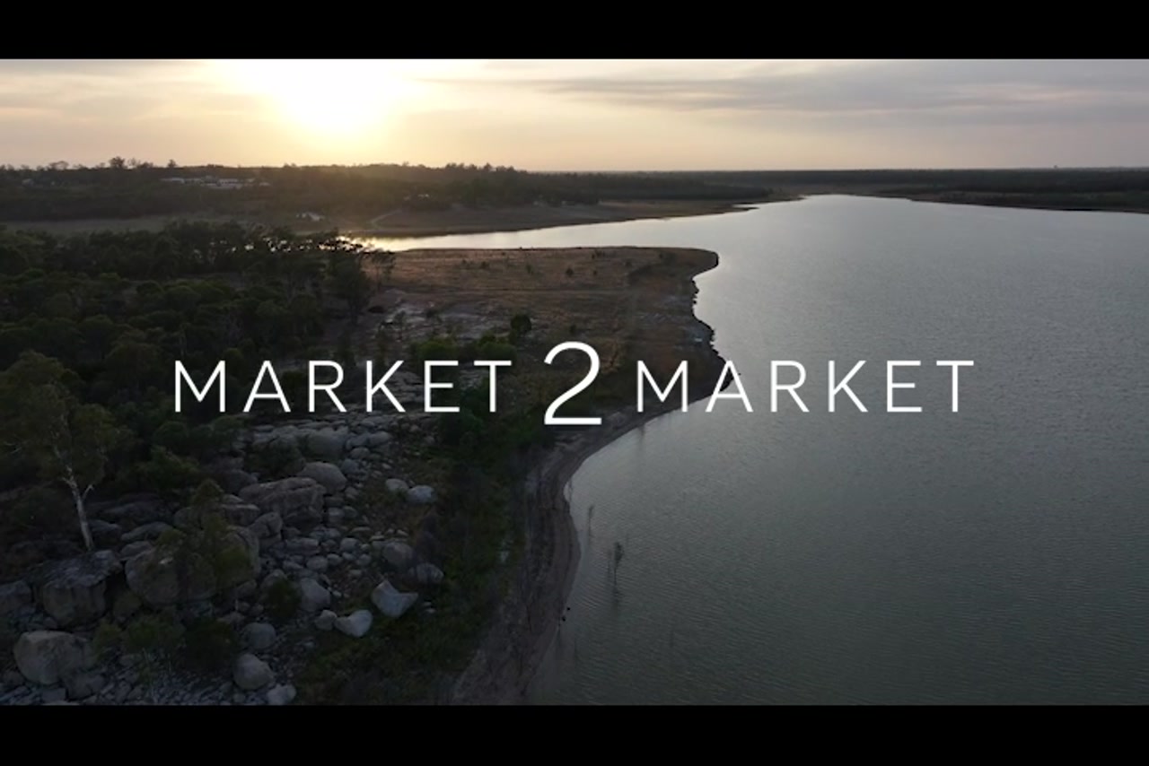 Aerial footage over river edge with rocky shoreline at dusk