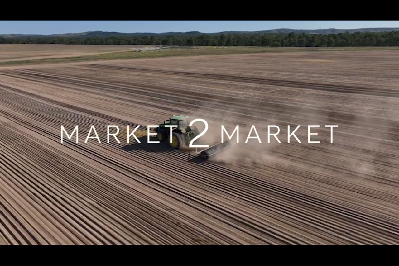 Aerial footage over tractor plowing a field in vast agricultural landscape