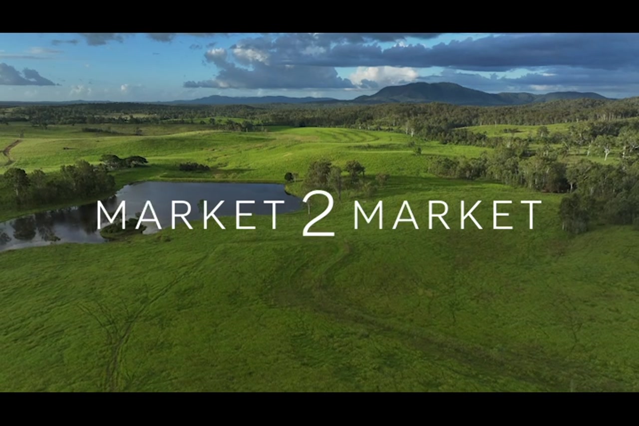 Aerial Footage over lush, green farmland with a small dam