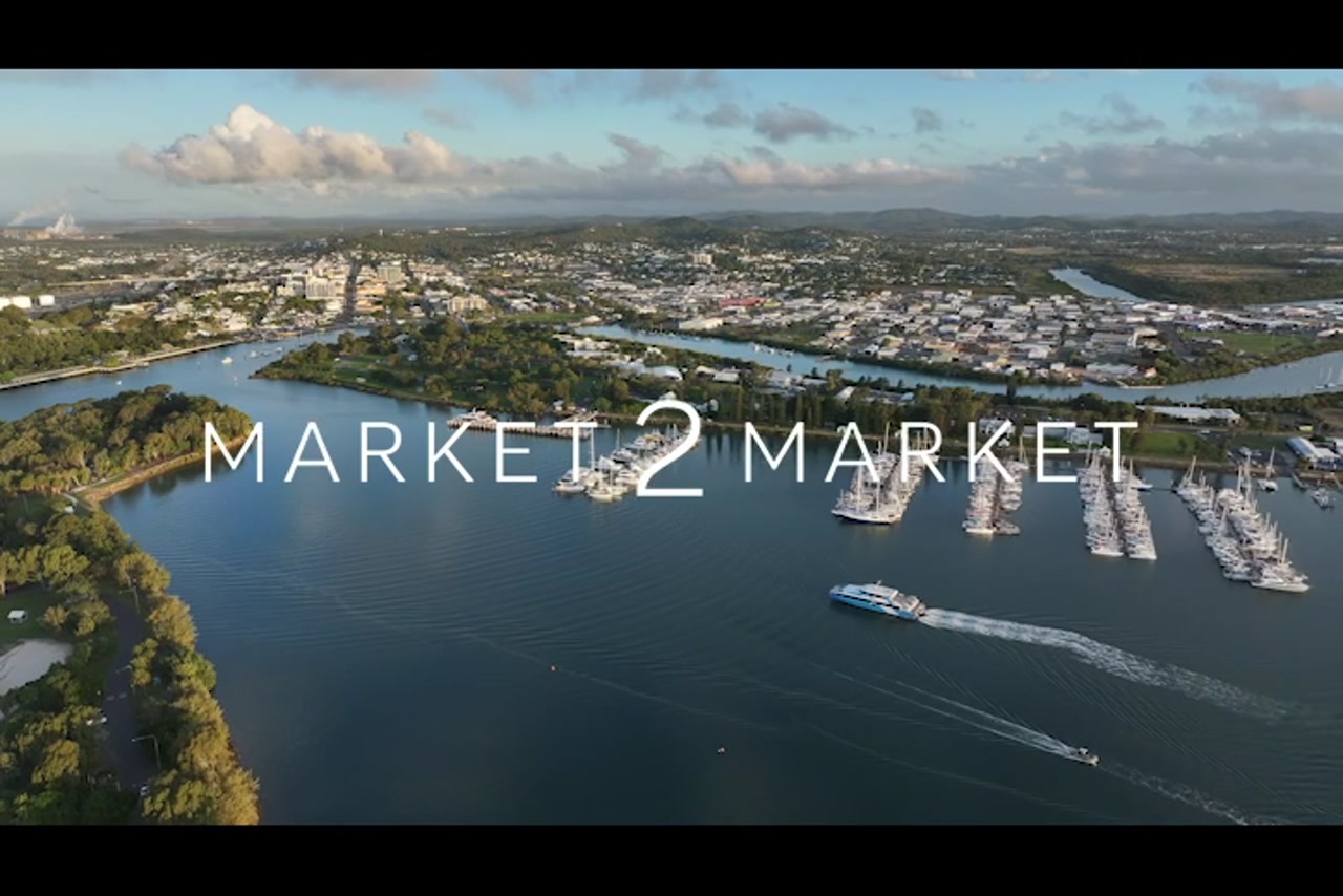 Aerial footage of ferry traveling past Gladstone Marina