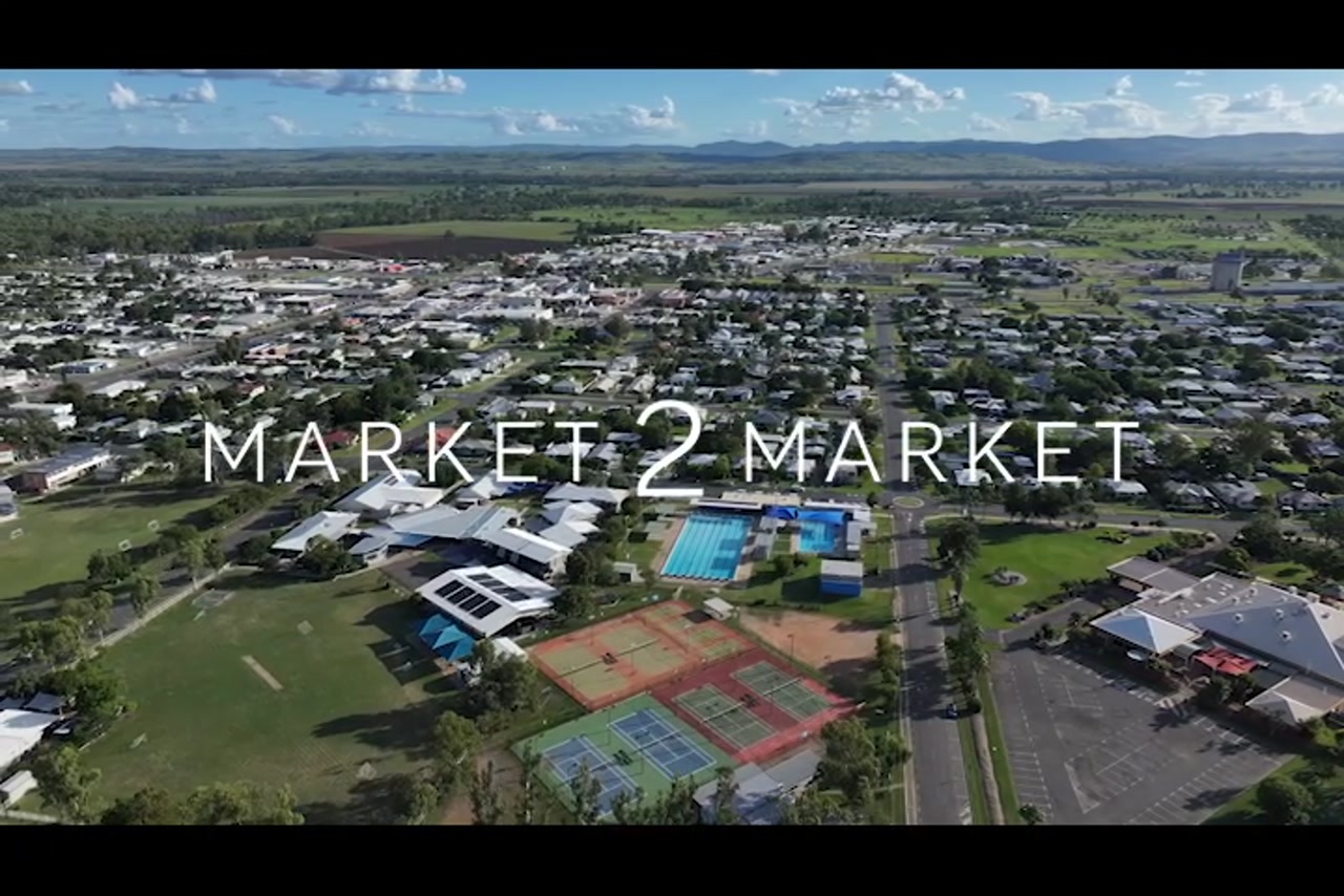 Aerial footage over residential area and a school wit swimming pools and tennis court in Rockhampton area