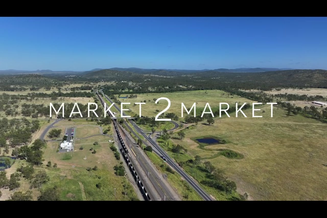 Aerial footage over highway  and train line in a regional area of Central Queensland